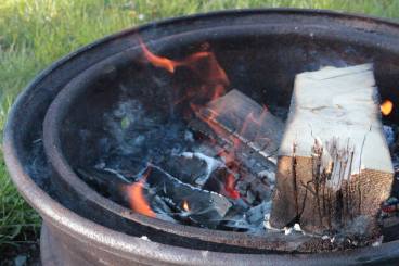 campfire camping fire wood flame hot ashes smolder coals grass outdoors